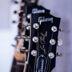 shallow focus photography black Gibson guitar headstock